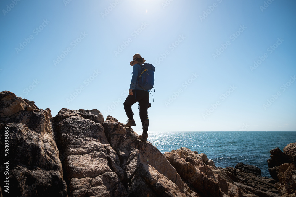 Woman photographer enjoy the view on sunrise seaside rocks