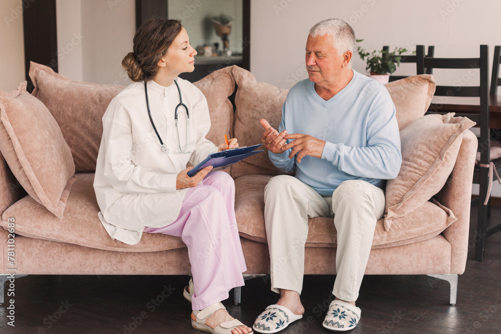 Female professional doctor showing medical test result explaining prescription using clipboard visiting senior elderly old man patient at home sitting on sofa - obrazy, fototapety, plakaty 
