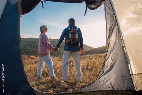Camping tent vacation Senior couple man and woman sitting near camp tent.