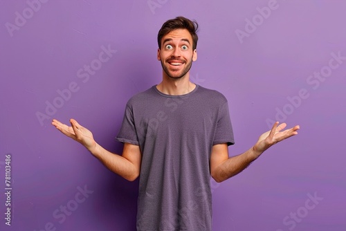 A man in a purple shirt is looking at the camera with his hands in his pockets photo