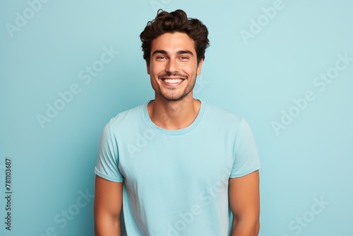 A man with a blue shirt is smiling and looking at the camera
