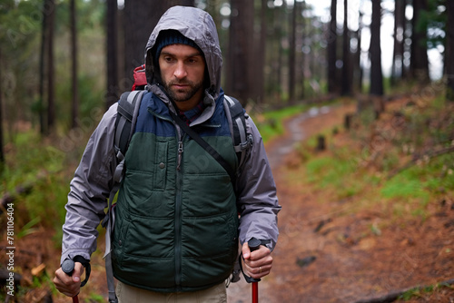 Hiking, backpack and man in forest for survival, shelter and dangerous conditions. Nature, winter and male person with trekking pole in rough environment, immigration and safe destination in Europe