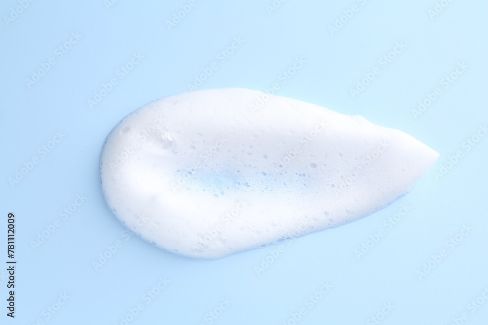 Obraz premium Sample of fluffy foam on light blue background, top view