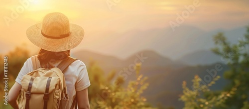 Young woman in straw hat with backpack, admiring sunset over mountains, outdoor travel adventure