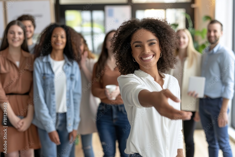 A diverse group of smiling people are standing in an office A diverse group of smiling people are standing in an office