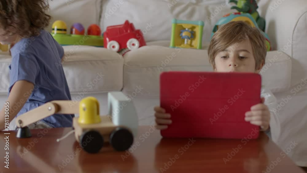 Two cute boys using a digital tablet in a bright room Two cute boys using a digital tablet in a bright room