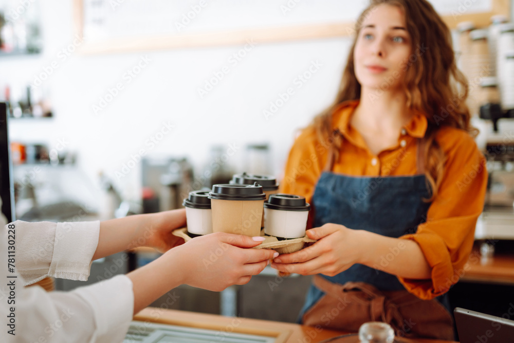 Ready order. Smiling barista in apron giving glass of coffee. Takeaway food. Ready order. Smiling barista in apron giving glass of coffee. Takeaway food.