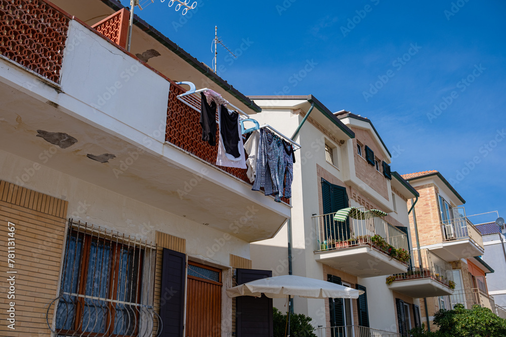 Washed clothes hang from the balcony and dry outside