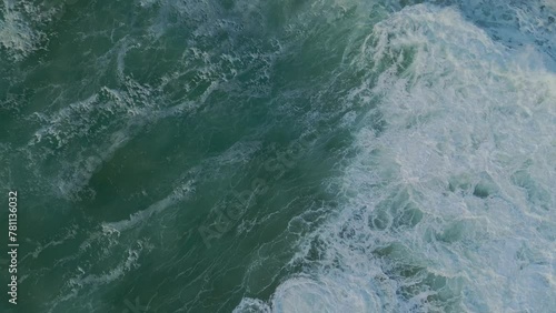 Ocean breaking waves on rocky coast. Drone tilt up shot. Ursa Beach, Portugal photo