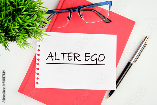 Text Alter ego is translated from Latin as the second self. a real or invented alternative personality of a person. Written on a piece of paper on a red notebook on a white background photo
