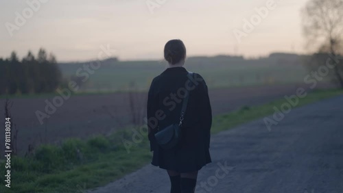 Sad young girl walking alone on the road. The loneliness of young people and the inability to find a relationship culminates in escaping into nature and closing off from society photo