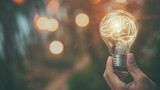 A person is holding a light bulb with a brain inside of it. Concept of innovation and creativity, as the brain inside the light bulb represents new ideas and thoughts