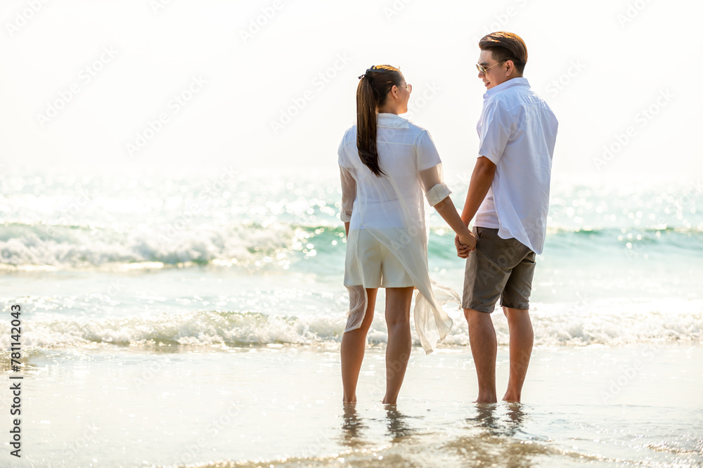 Happy Asian family adult couple enjoy outdoor lifestyle travel nature ocean on summer holiday vacation. Husband and wife walking and looking beautiful nature of tropical island beach at sunset. Happy Asian family adult couple enjoy outdoor lifestyle travel nature ocean on summer holiday vacation. Husband and wife walking and looking beautiful nature of tropical island beach at sunset.
