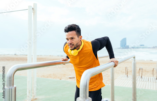 Young man training at the beach in the morning. Athlete exercising with sport equipment outdoor. photo