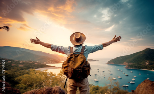 Happy wanderer with backpack admiring the mountain landscape from behind