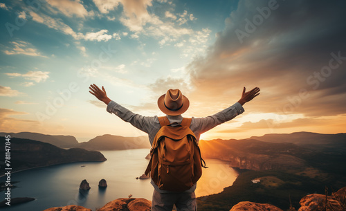 Thrilled hiker with backpack on the mountain top viewed from the back