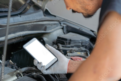 Technician man checking car engine and holding smartphone with isolate screen. Car service, repair, fixing.