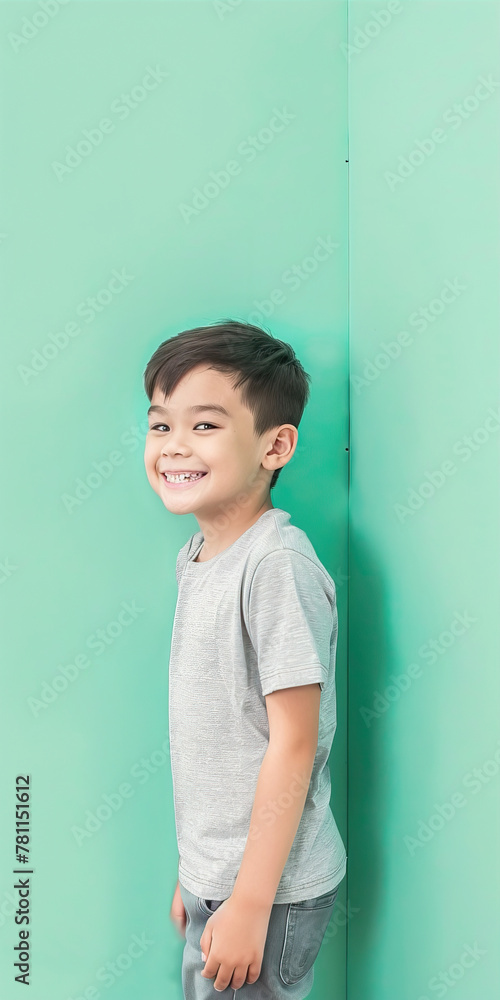 Smiling boy standing on mint background
Smiling boy standing on mint background