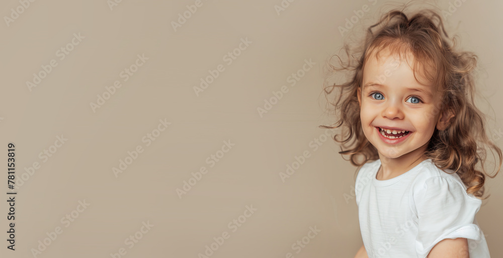 Little girl on a beige background smiling
Little girl on a beige background smiling