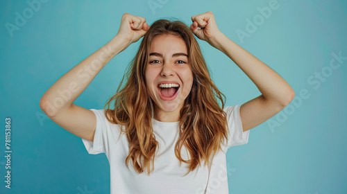 Portrait of an excited young young woman isolated on blue background 