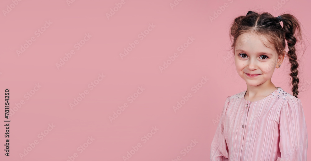 Little girl on a pink background smiling
