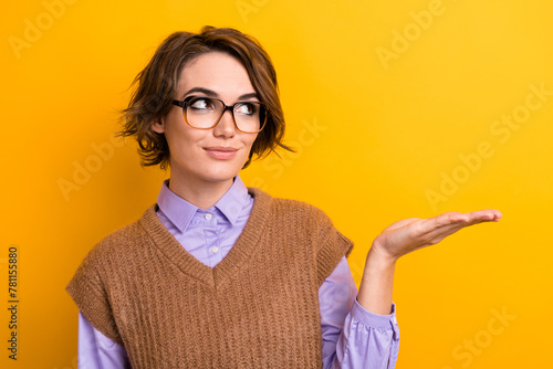 Fotografie Photo of positive girl dressed knitwear waistcoat in glasses look at product on