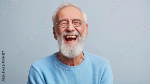 Portrait of old man wearing a blue sweater and glasses. laughing old man whit a beard, in glasses, happy against gray background. photo