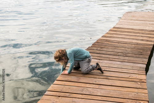 Wallpaper Mural Little boy on wooden boardwalk leading into lake waters Torontodigital.ca