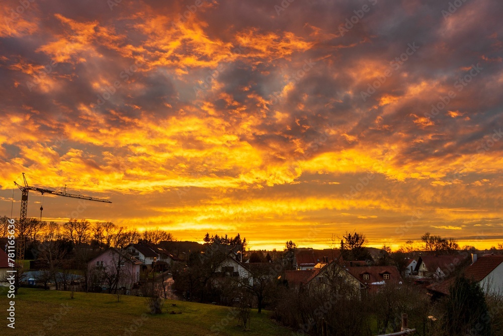 Obraz premium Beautiful bright sunset sky over a city in the evening