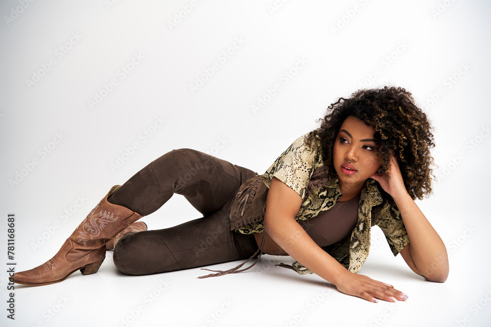 good looking african american woman with animalistic print on her outfit lying and looking away