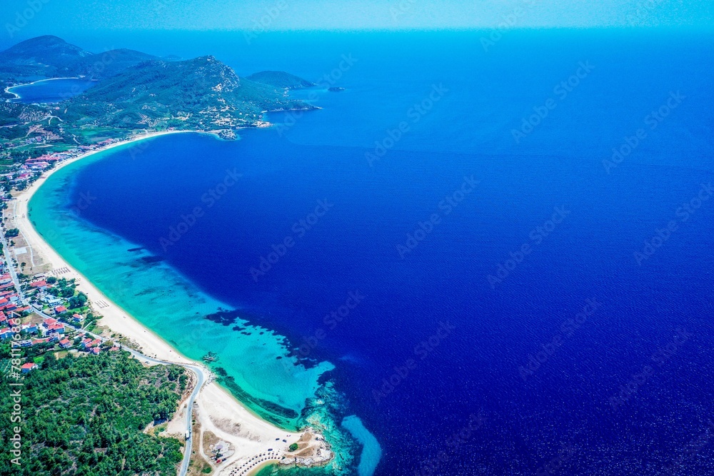 Aerial view of clear blue sea and buildings by the shoreline