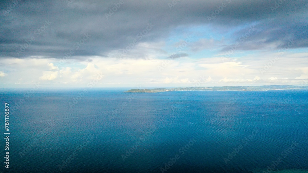 Scenic view of dark cloudy sky over clear blue endless ocean