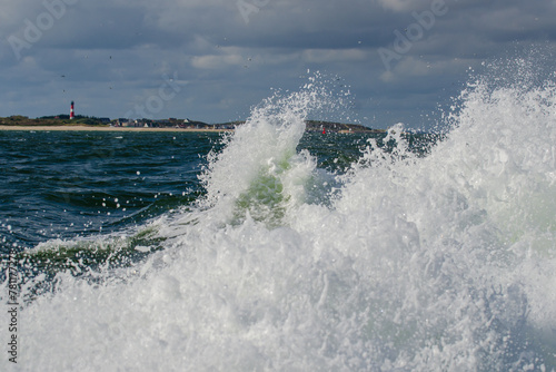 Leuchtturm Hörnum auf Sylt vom Schiff aus gesehen mit Wellen und Brandung