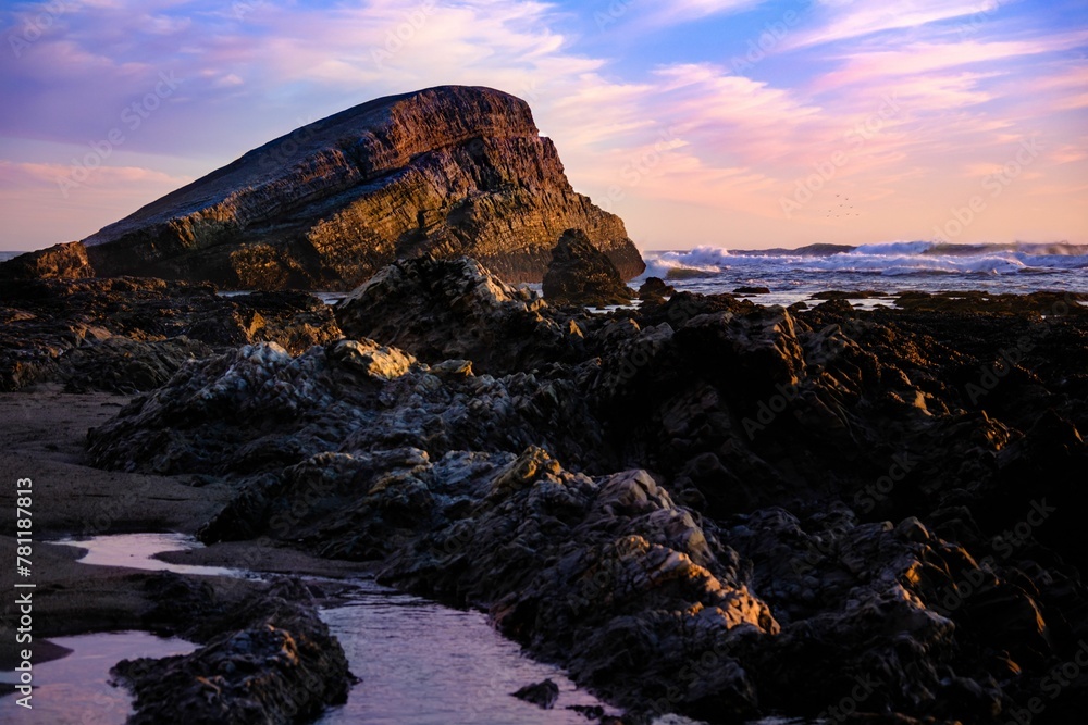 Beautiful rocky shore of the sea during purple sunset