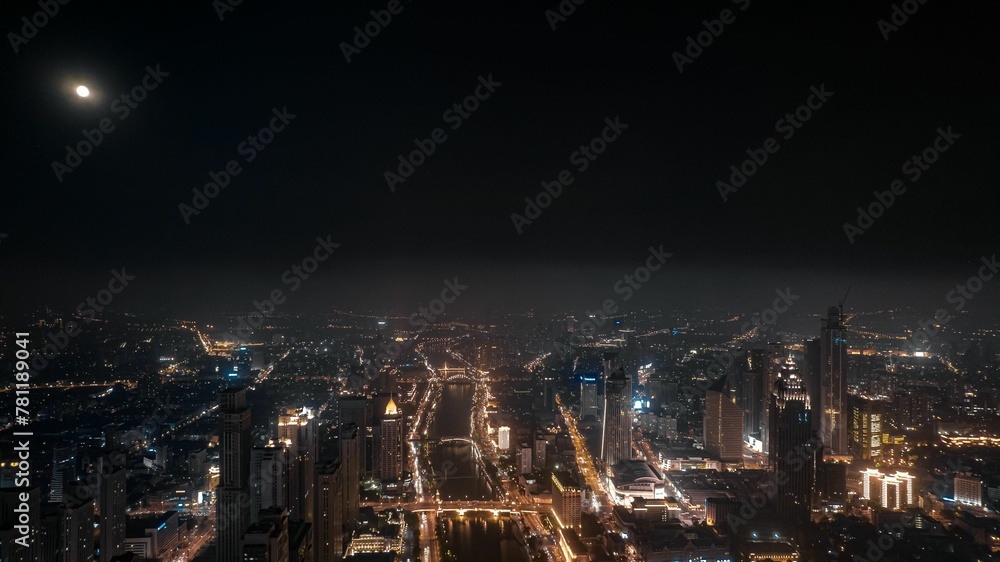 Obraz premium Aerial shot of glowing cityscape with the city traffic at night