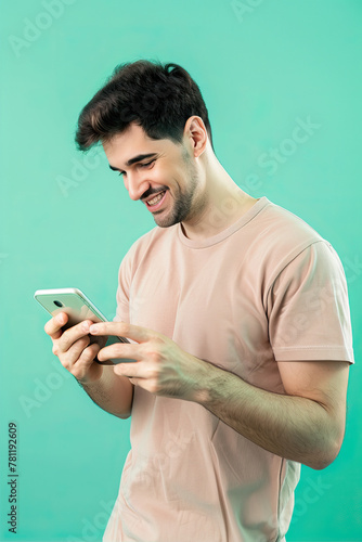 A man on a turquoise background looks at the phone 