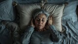 Depressed senior woman lying in bad, insomnia concept