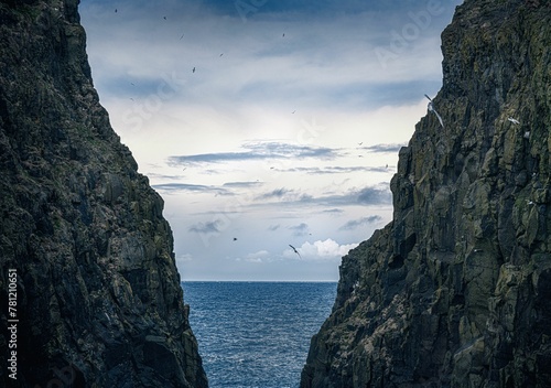 Photography Beautiful shot of a seascape taken from in between two cliffs under the clouds