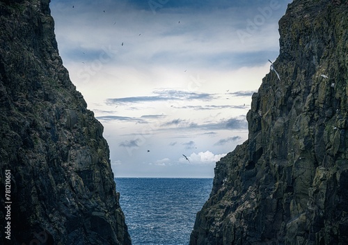 Beautiful shot of a seascape taken from in between two cliffs under the clouds