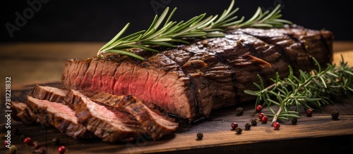 Grilled flank steak with rosemary on board photo