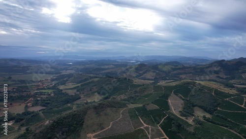 Aerial shot of mountains with green coverages and a skyline