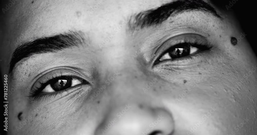 Intense macro close-up face of one young black woman facial eyesight features in monochrome, black and white gaze at camera Intense macro close-up face of one young black woman facial eyesight features in monochrome, black and white gaze at camera