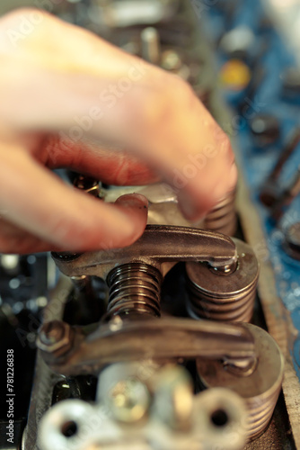 Vertical closeup shot of a mechanic mounting the car engine