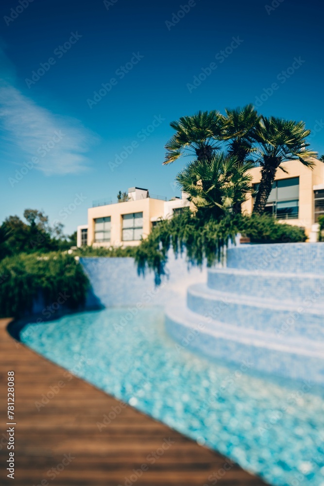 Vertical shot of an empty outdoor swimming pool in a resort area on a sunny day
