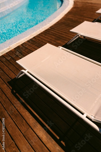 Vertical high-angle shot of folding chairs before a swimming pool