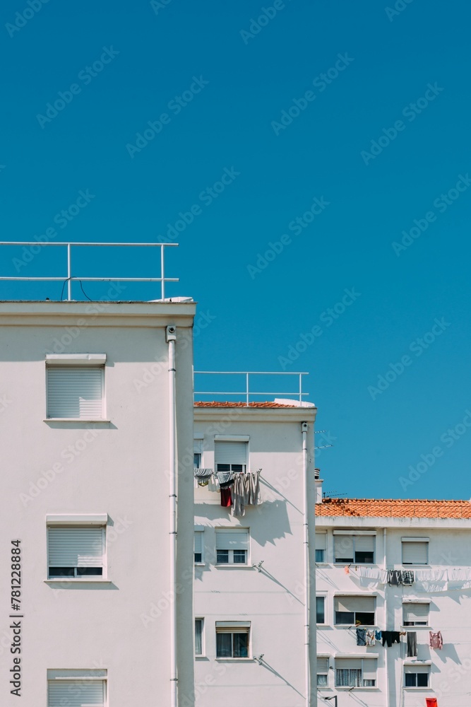 Vertical shot of a white residential building with hanging laundry