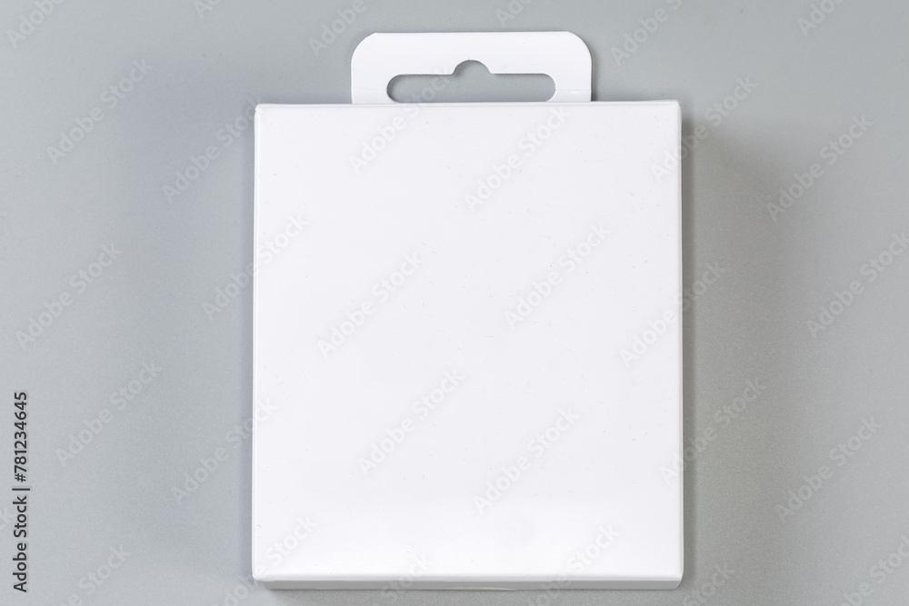 White rectangular cardboard hang tab packing box on gray surface White rectangular cardboard hang tab packing box on gray surface