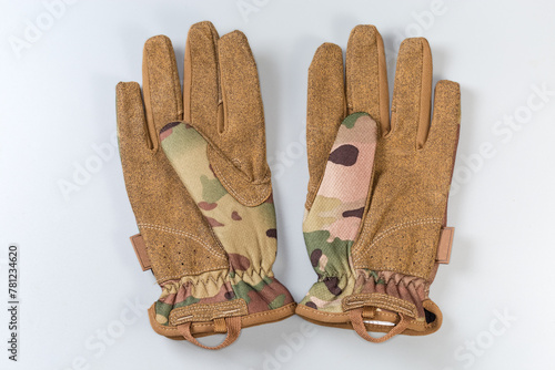 Green-brown tactical military gloves on a gray background © An-T