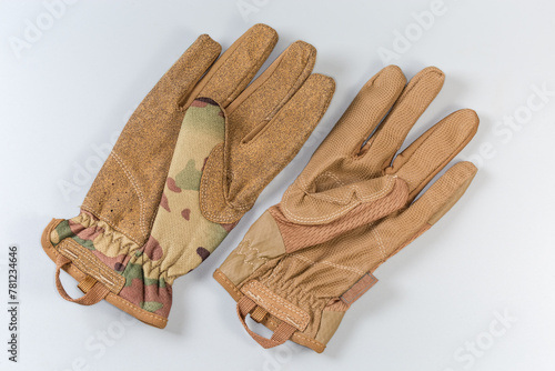 Different tactical military gloves protective color on a gray background © An-T
