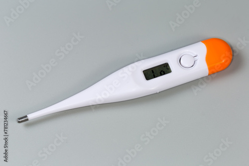 Electronic medical thermometer ready to use on a gray surface © An-T